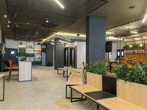 Un espacio de oficina moderno con escritorios abiertos, sillas ergonómicas y una combinación de luz natural e iluminación artificial.
