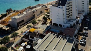 Un área urbana costera con edificios modernos, cielo azul despejado y vista al mar.