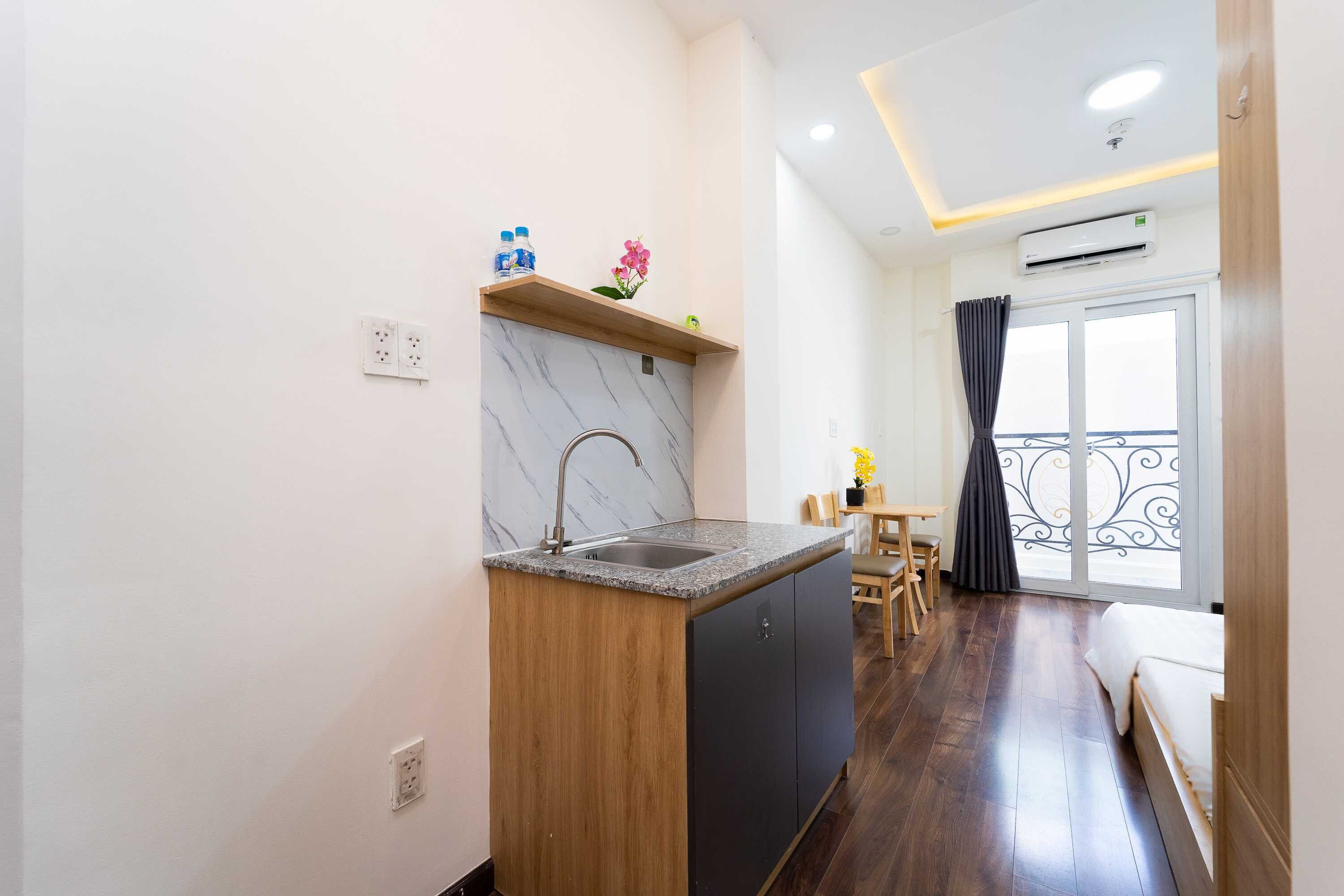 Una cocina compacta con salpicadero de mármol, encimera de madera y lavavajillas integrado.