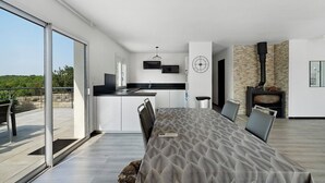 Een modern interieur met een eethoek, keuken en een open haard.