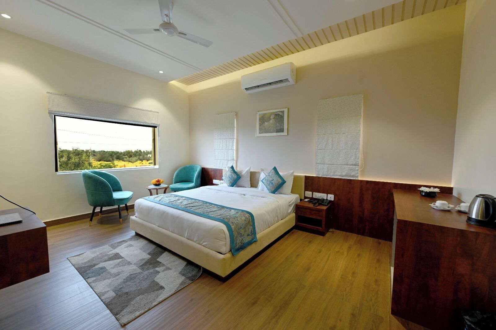Een moderne hotelkamer met een groot bed, een bureau, een stoel en uitzicht op de omgeving.