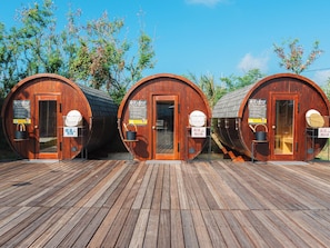 Three wooden barrel-shaped structures with doors, each with a sign indicating self-ownership. - MIYAKOJIMA Blue Village HOTEL & SAUNA (Miyakojima)