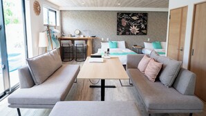 A modern living room with a sofa, a coffee table, and a desk area.