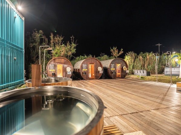 A pool area with wooden barrels, a blue container, and a wooden deck. - MIYAKOJIMA Blue Village HOTEL & SAUNA (Miyakojima)