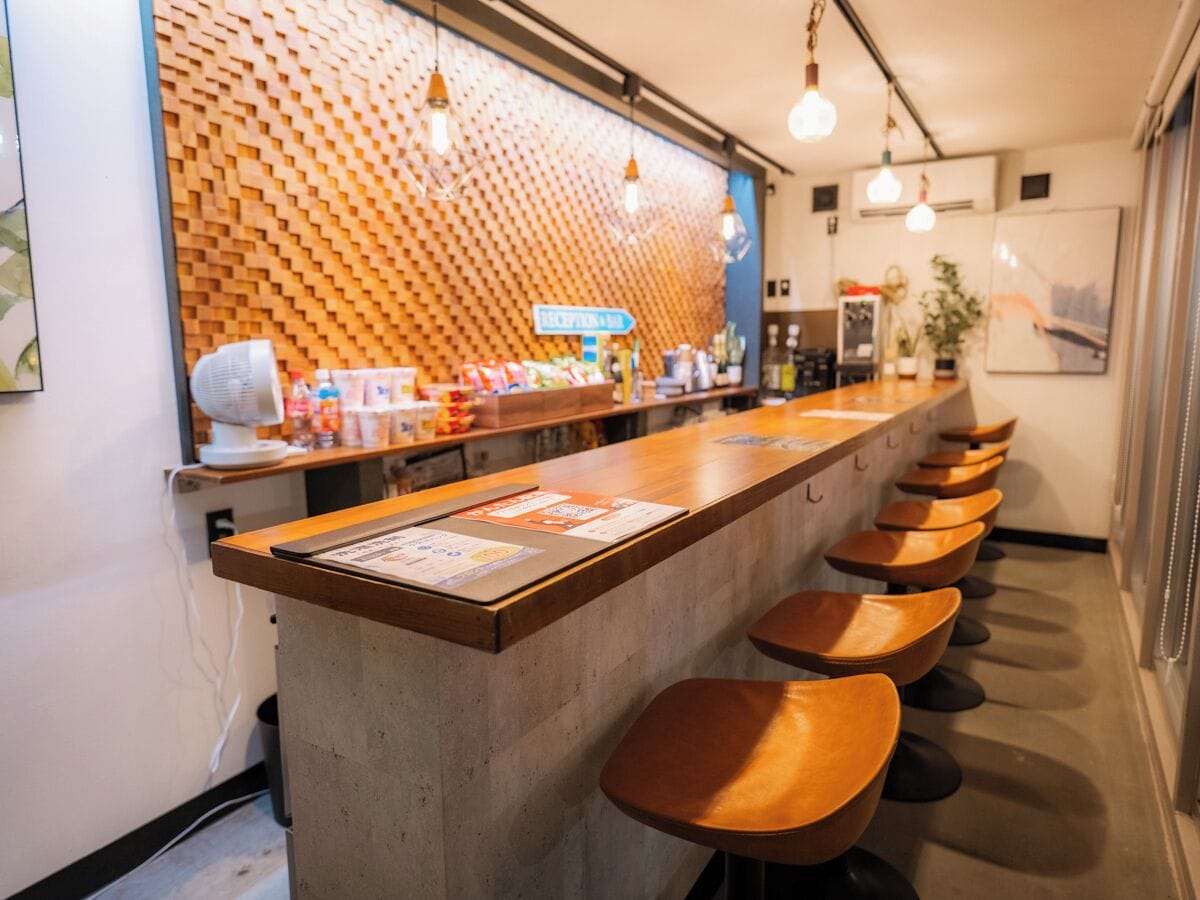Eine Bar mit einer langen Theke und mehreren Hockern.