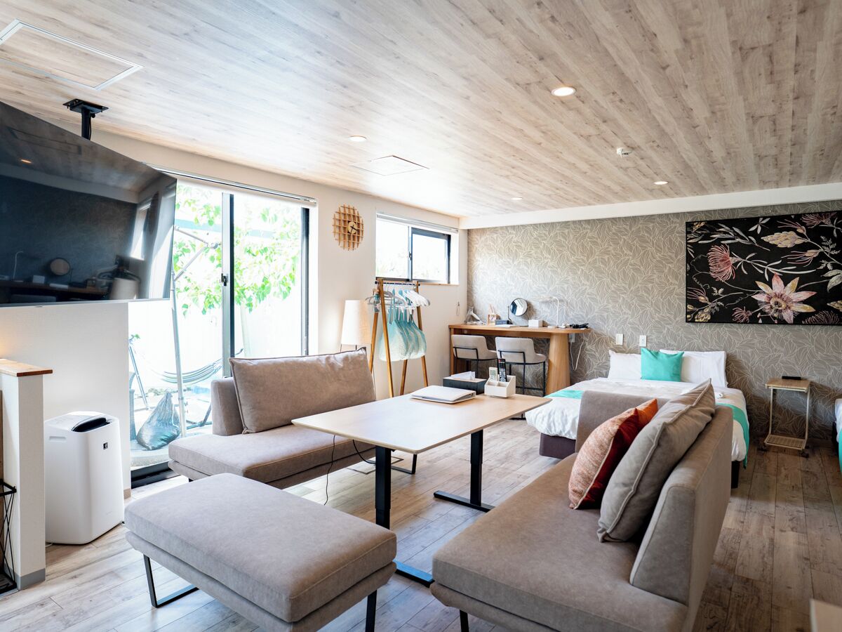 A modern living room with a sofa, coffee table, and a painting on the wall.