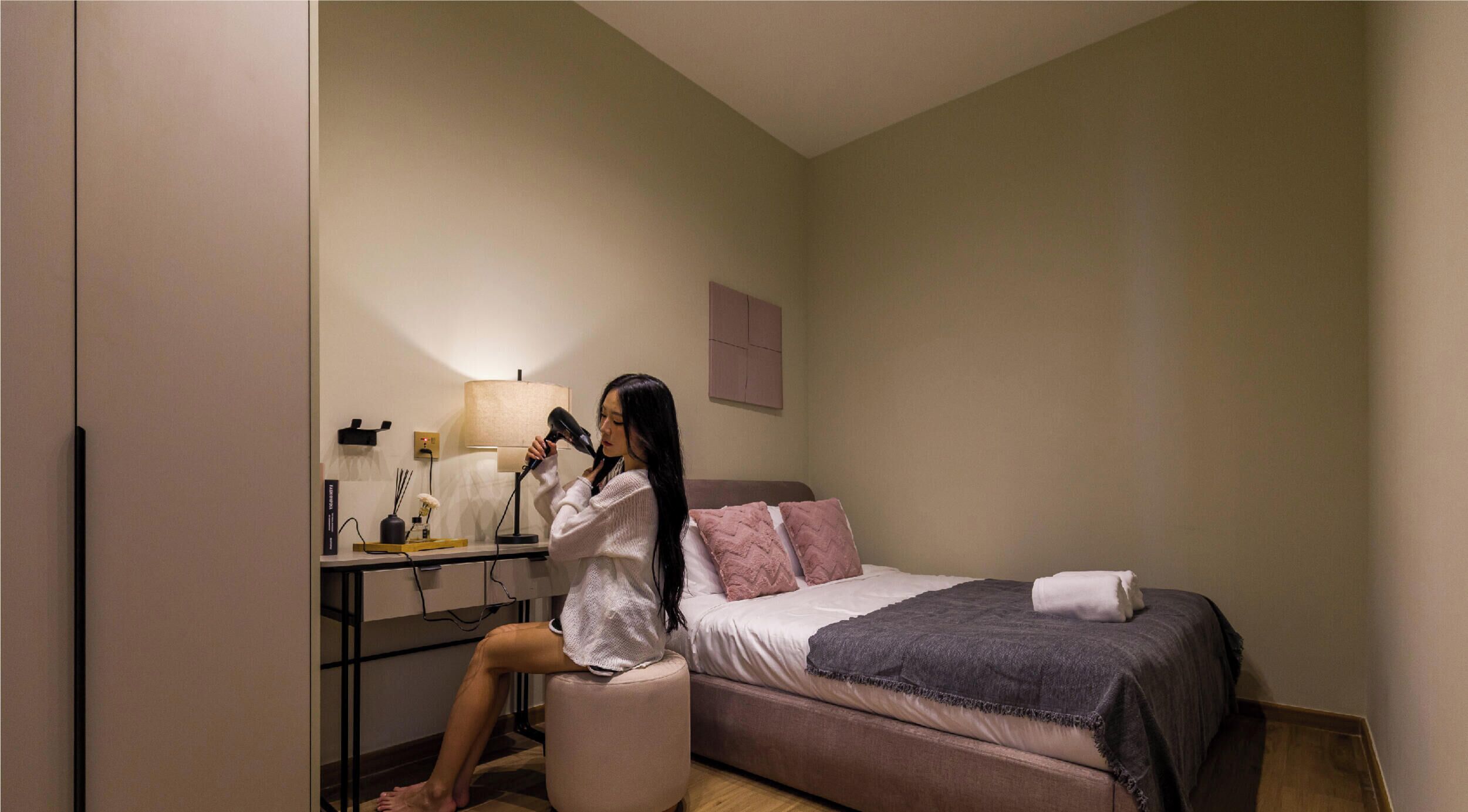 A hotel room with a bed, a desk, and a chair.