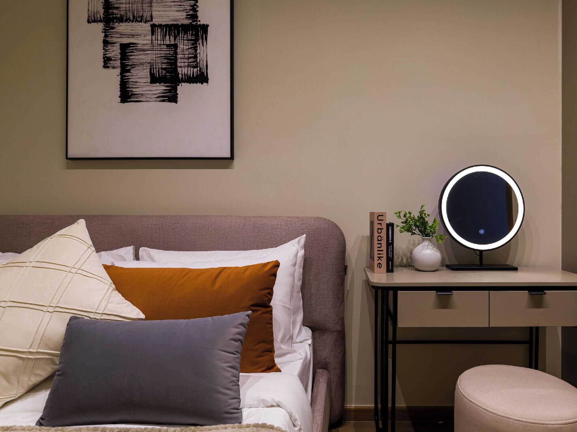 Un dormitorio con cama, mesita de noche y espejo en la pared.
