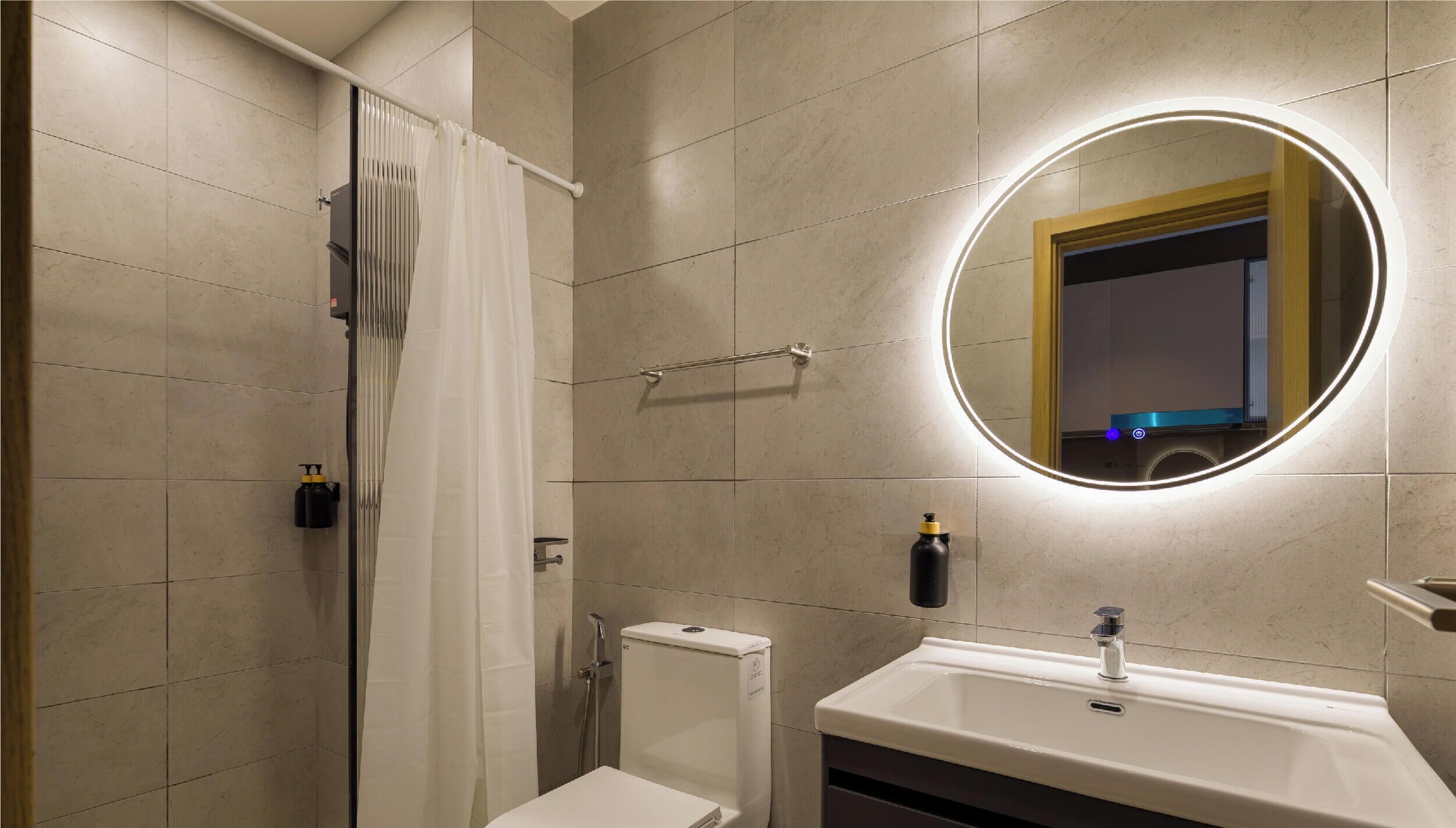Une salle de bain moderne équipée d’une douche, de toilettes et d’un lavabo.