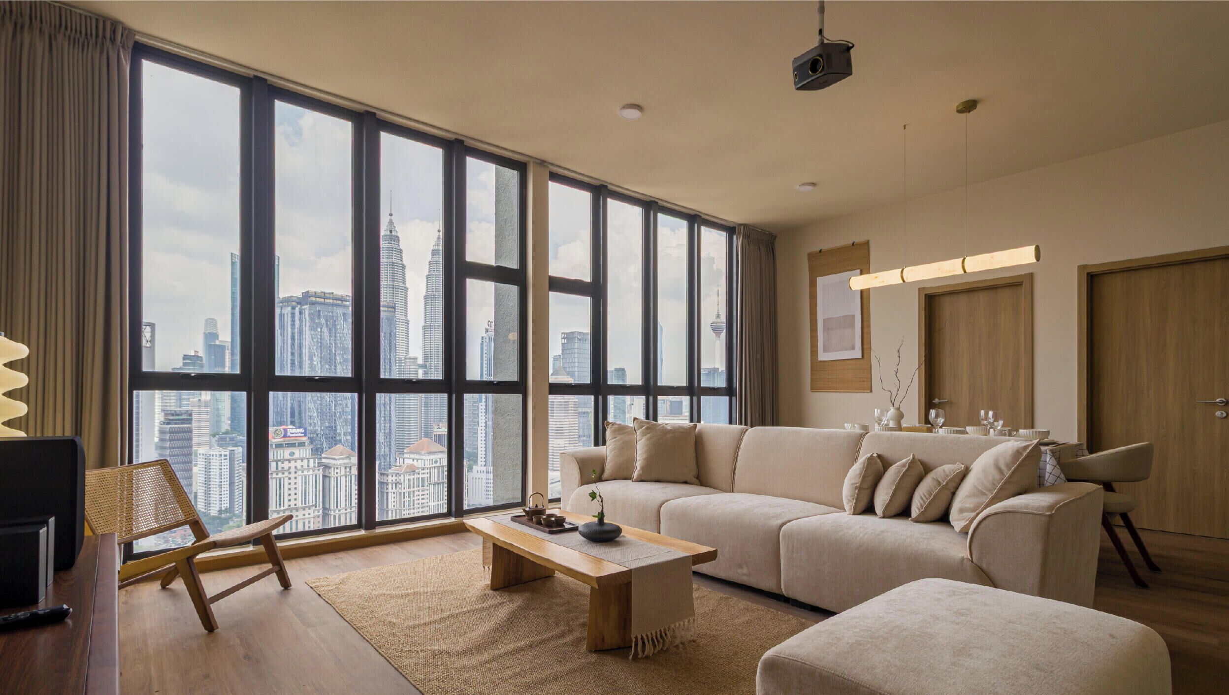 A spacious living room with a large window, a sofa set, a coffee table, and a television.