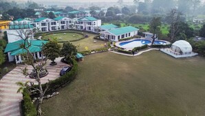 Ein großes Resort mit mehreren Gebäuden, einem Schwimmbad und einer kuppelartigen Struktur.