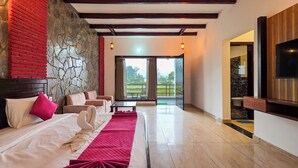 Ein Hotelzimmer mit einem Bett, zwei Sofas, einem Couchtisch und einem Balkon mit Blick.