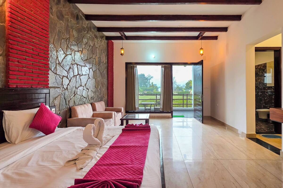 Ein Hotelzimmer mit einem Bett, zwei Sofas, einem Couchtisch und einem Balkon mit Blick.