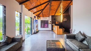 Eine geräumige Lobby mit hoher Decke, einem Empfangsbereich, Sitzbereichen und großen Fenstern mit Blick ins Freie.