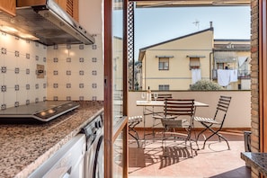 Une cuisine équipée d’une cuisinière, d’un four et d’un coin repas avec une table et des chaises.