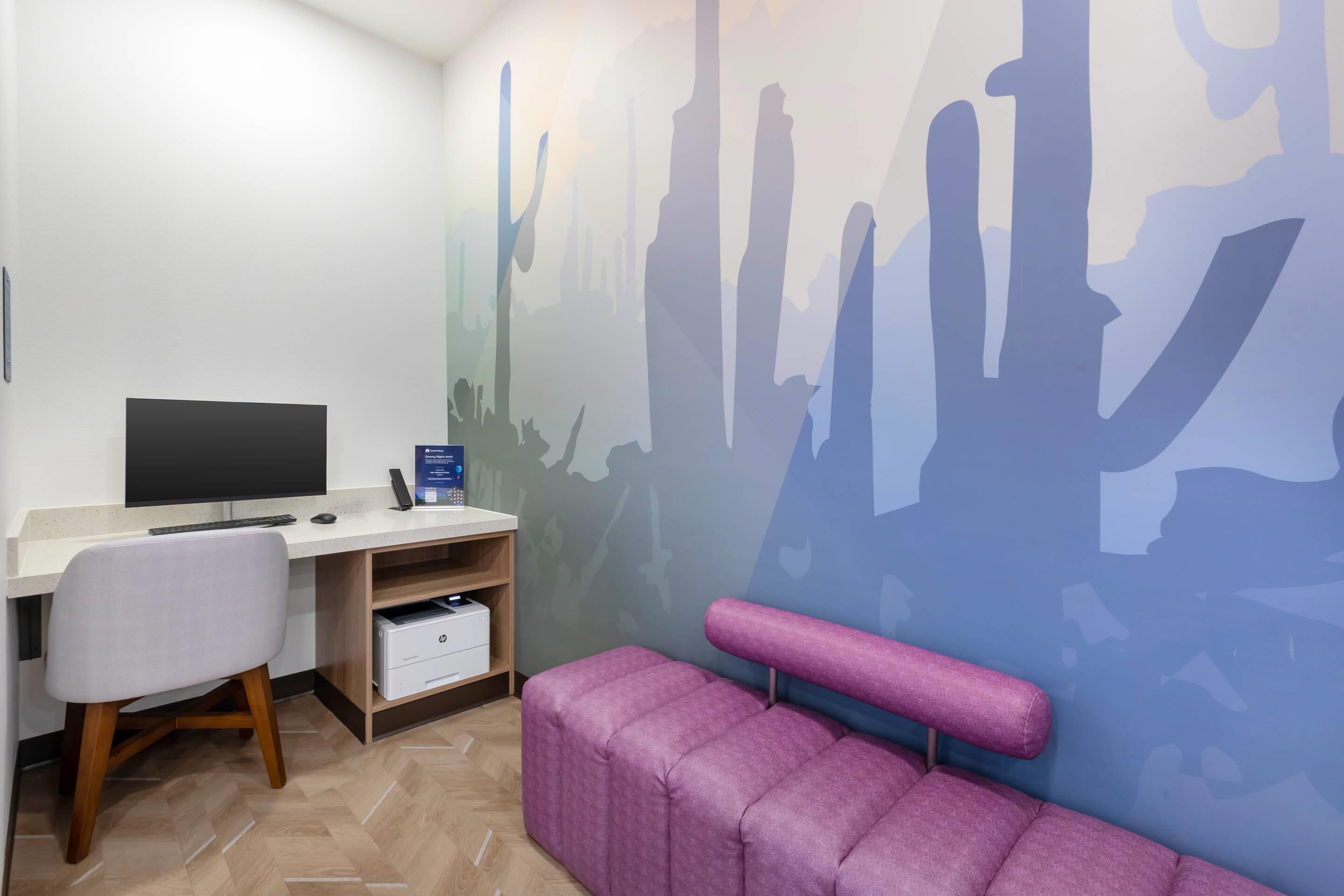 A modern office space with a desk, chair, and a large wall mural.