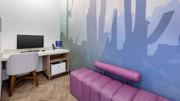 A modern office space with a desk, chair, and a large wall mural.