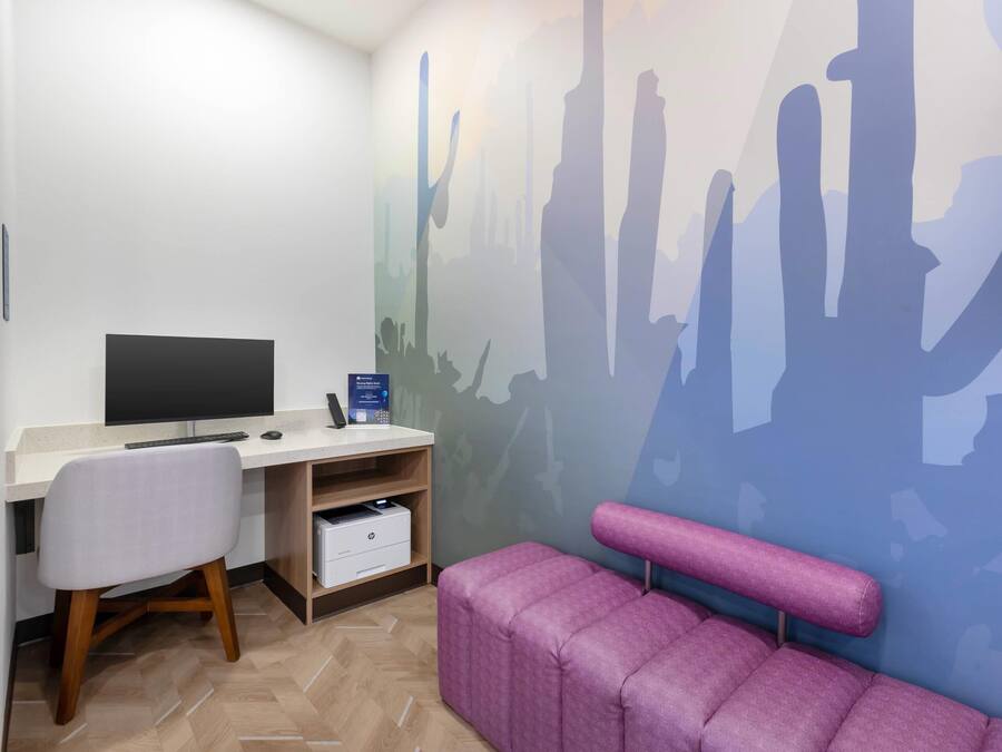 A modern office space with a desk, chair, and a large wall mural.