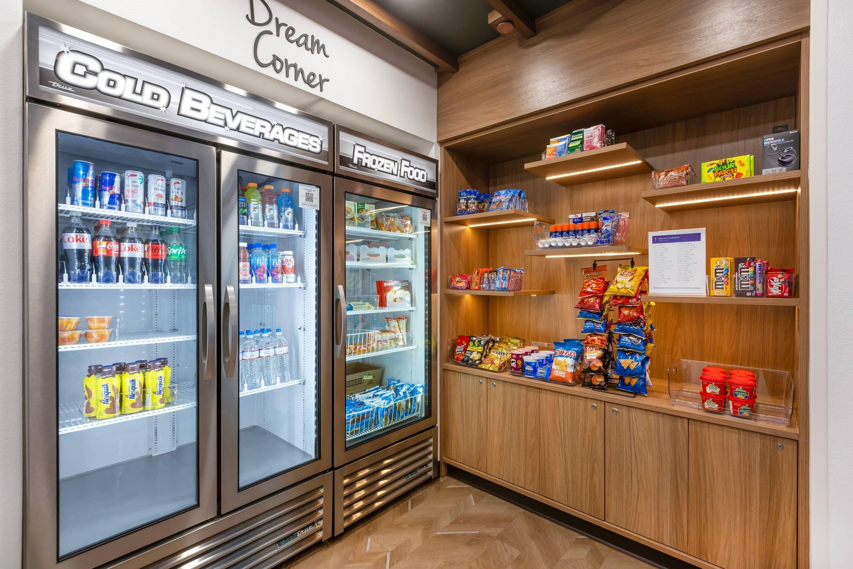 A cold beverage and frozen food vending area with snacks and a menu sign.