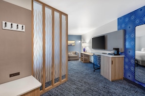 A hotel room with a desk, a TV, a sofa, and a bed. - Sleep Inn & Suites Henderson – Las Vegas (Henderson)