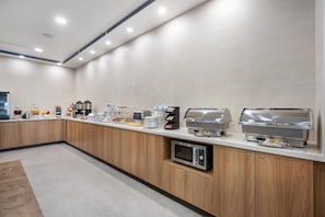 A modern kitchen area with a long counter, equipped with coffee makers, a microwave, and a toaster. - Sleep Inn & Suites Henderson – Las Vegas (Henderson)