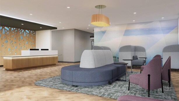A modern reception area with a wooden reception desk, a large seating area with a sofa and chairs, and a mural on the wall. - Sleep Inn & Suites Henderson – Las Vegas (Henderson)