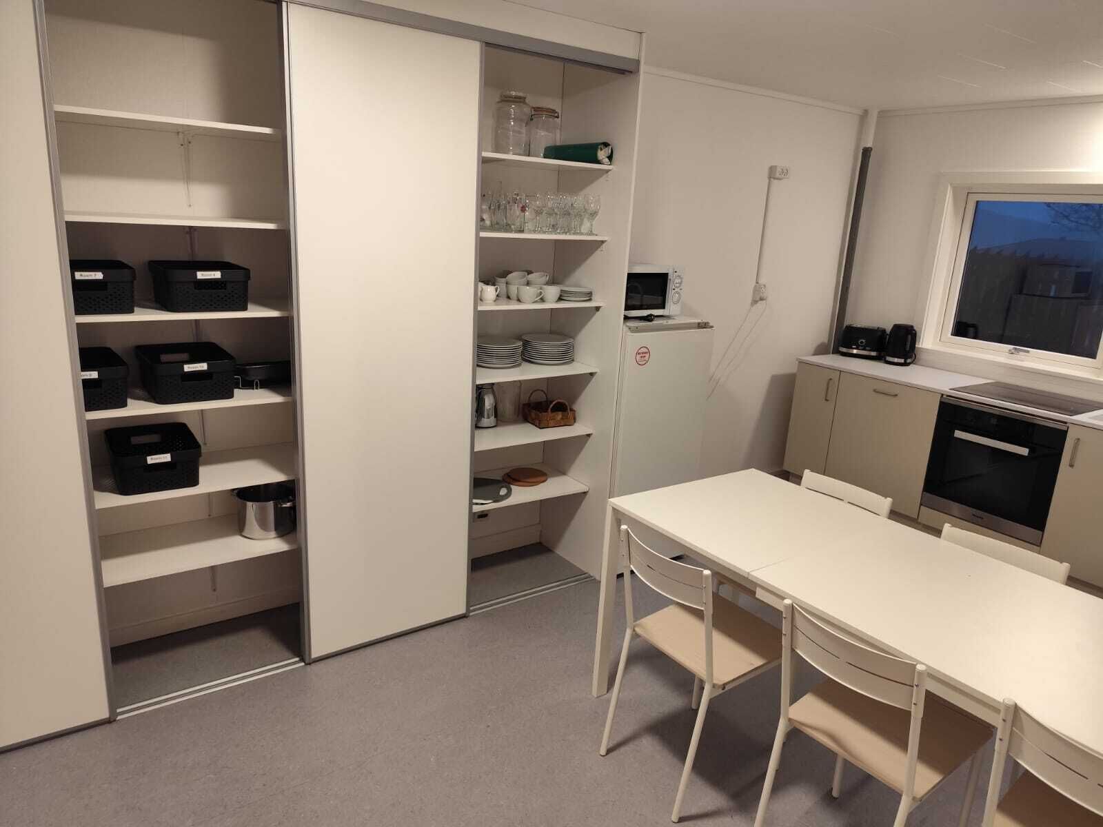 A compact kitchen with white cabinets, a microwave, a coffee maker, and a window.