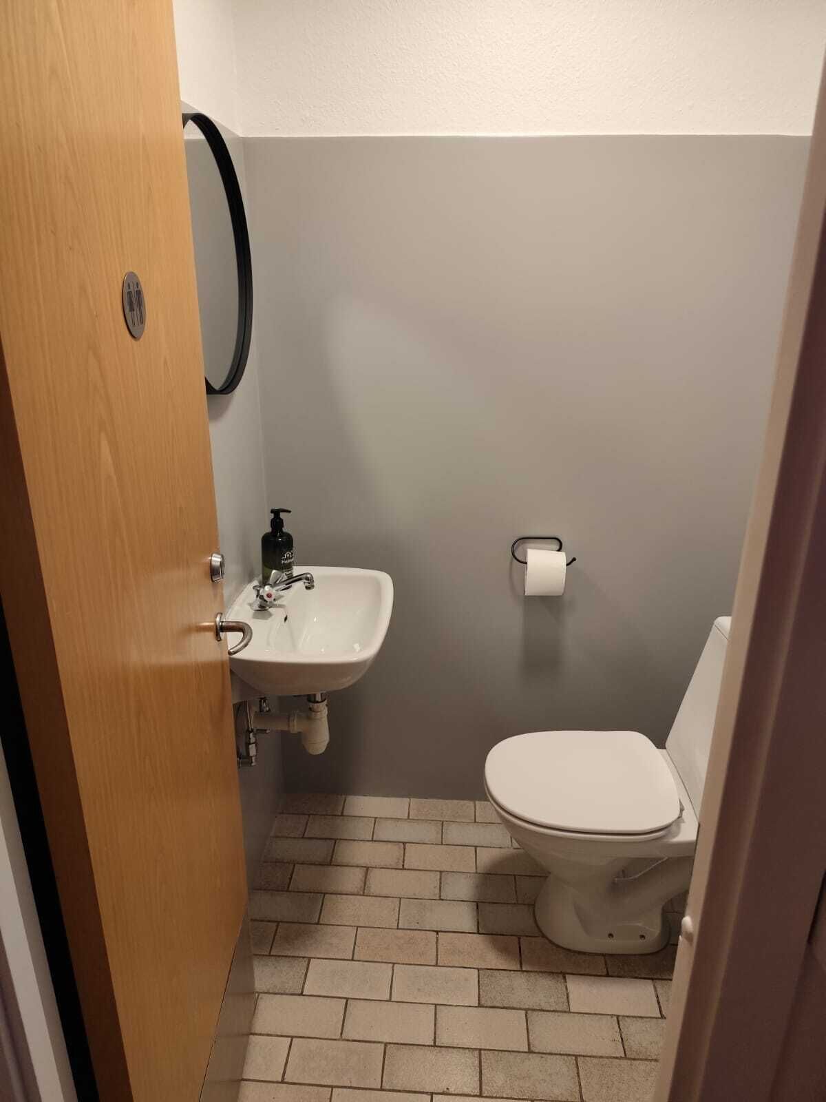 Un baño pequeño con lavamanos, inodoro y espejo.
