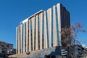 A tall building with vertical windows and a flat roof. - Hotel Nodo (Santiago)