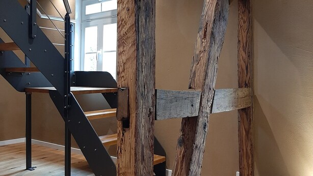 A staircase with a modern design, wooden beams, and a metal handrail. - Historic vacation home in Bacharach with parking space (Bacharach)