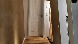 A hallway with exposed wooden beams, a white door, and a light switch on the wall. - Historic vacation home in Bacharach with parking space (Bacharach)
