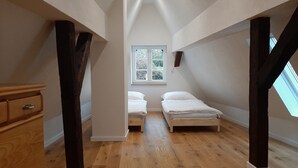 A small attic bedroom with two single beds, wooden flooring, and a skylight. - Historic vacation home in Bacharach with parking space (Bacharach)