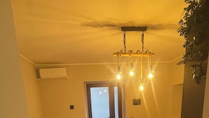 Uma sala de estar aconchegante com um sofá, uma mesa de jantar com cadeiras e uma área de cozinha.