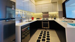 Una cocina moderna con lavavajillas integrado, estufa a gas y refrigerador de acero inoxidable.