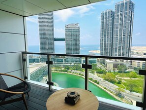 Un balcon avec vue sur des immeubles de grande hauteur et un plan d’eau.