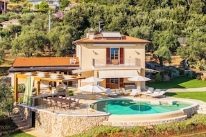 A two-story villa with a swimming pool, outdoor seating, and a stone wall. - Villa Palatina - Vivere Housing (Toscana)