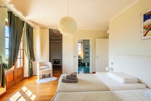 A bedroom with a large bed, a chair, a fluffy rug, and a hanging light fixture. - Villa Palatina - Vivere Housing (Toscana)