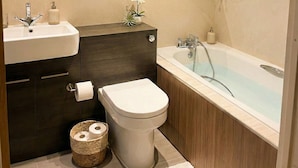 A modern bathroom with a sink, toilet, and bathtub. - Kew Connection -
Relax in this light airy river view apartment. (Brentford)