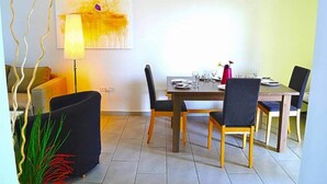 Un comedor con una mesa de madera, sillas negras y una lámpara.