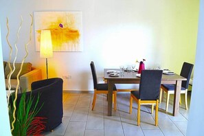 Ein Essbereich mit einem Holztisch, schwarzen Stühlen und einer Lampe.