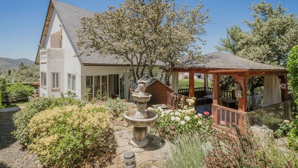 A house with a garden, a fountain, and a wooden gazebo. - La Rosa De Los Vientos, Villa with Pool & Hot Tub in Sierra de Guadarrama (Los Ángeles de San Rafael)