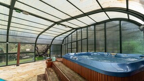 A greenhouse with a hot tub, wooden deck, and a pool. - La Rosa De Los Vientos, Villa with Pool & Hot Tub in Sierra de Guadarrama (Los Ángeles de San Rafael)