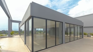 A modern building with large glass windows, a flat roof, and potted plants. - Sky Suites BRAVIA RESIDENCE OSU (Accra)