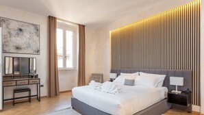 Ein modernes Schlafzimmer mit einem großen Bett, Nachttischen, einem Schreibtisch und einem großen, abstrakten Gemälde.