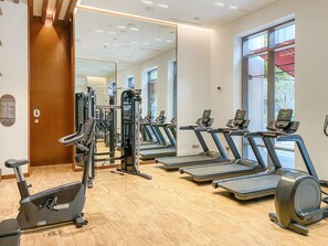 A gym with exercise equipment, large windows, and a wooden floor. - FIRST CLASS | 3BR | Luxury Living at Creek Beach (Dubai Creek Harbour)
