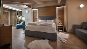 Une chambre moderne avec un grand lit, un canapé gris et un plafond en bois.