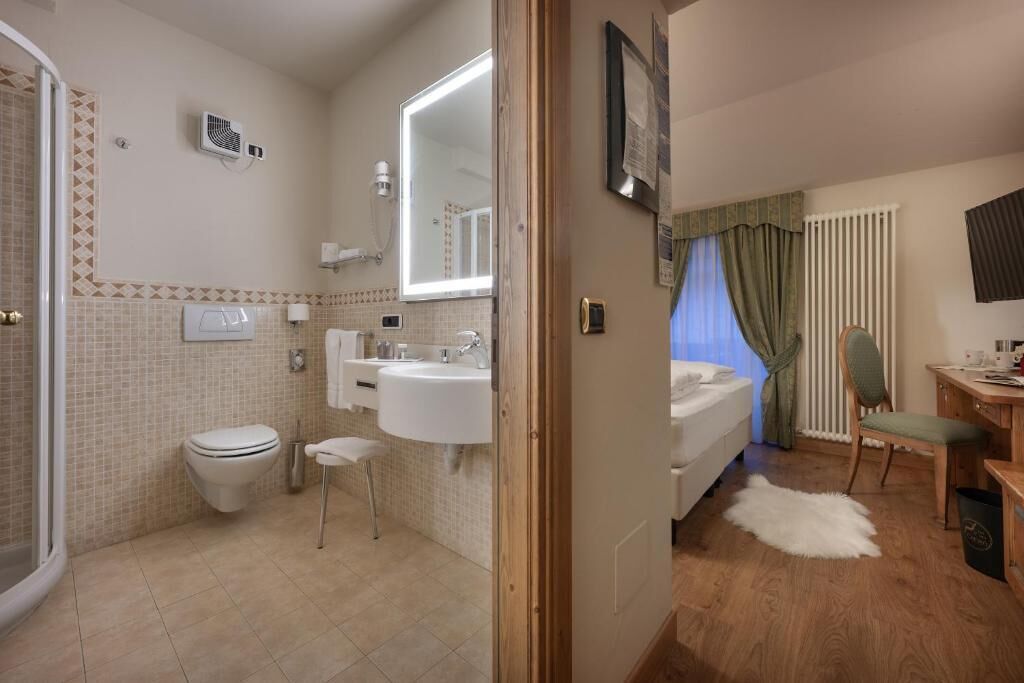 Baño con inodoro, lavamanos y ducha.