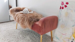 A chair with a plush fur backrest and a solid pink seat, positioned against a wall with a colorful abstract painting. - Studio room near Koblenz (Sankt Sebastian)