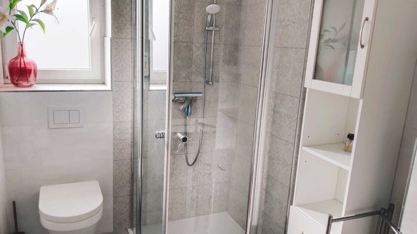 Een douche, handdoeken, zeep, toiletpapier