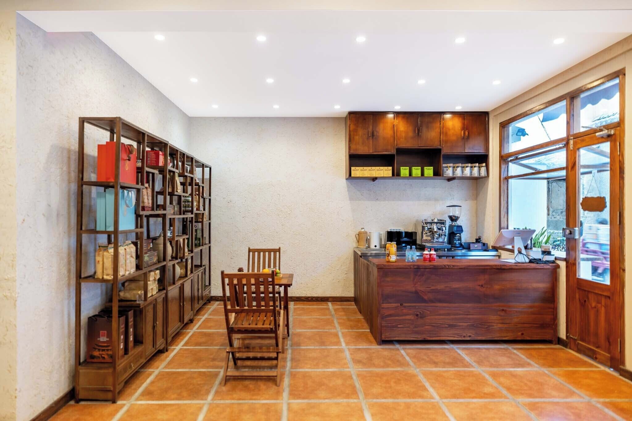 A kitchen with wooden cabinets, a dining table with chairs, and a coffee machine.
